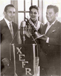 Ante el estandarte y micrófono de la X.E.F.R., la Cantante Rosita Quintana y el Compositor Cuco Sánchez